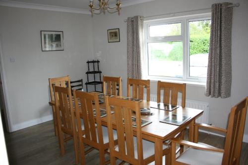 een eetkamer met een tafel en stoelen en een raam bij Carrowbruagh in Limavady