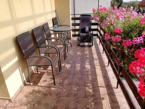a balcony with chairs and tables and flowers at Pokoje AGA in Mikołajki