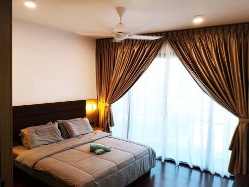 a bedroom with a bed with a teddy bear on it at ALMAS PUTERI HARBOUR in Nusajaya
