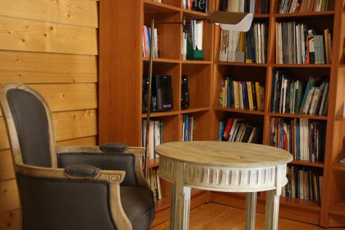 a table and a chair in front of a book shelf at Casa de l Bárrio in Picote