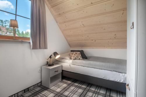 a small bedroom with a bed and a window at Harny Domek in Kościelisko