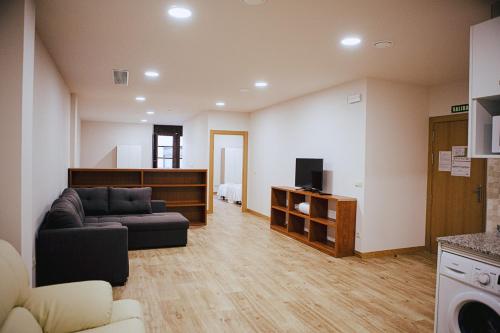 a living room with a couch and a tv at Apartamentos Ducay in Olite