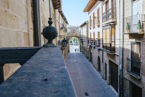 an empty alley in a city with buildings at Apartamentos Ducay in Olite