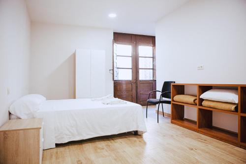 a bedroom with a bed and a desk and a chair at Apartamentos Ducay in Olite
