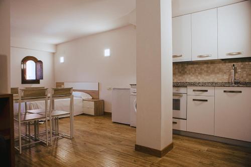a kitchen with white cabinets and a bed in a room at Apartamentos Ducay in Olite
