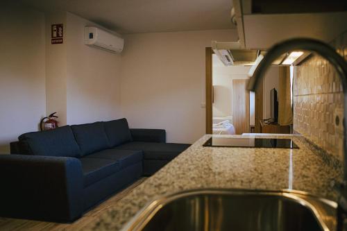 a living room with a couch and a sink at Apartamentos Ducay in Olite