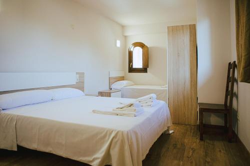 a bedroom with a large white bed and a tub at Apartamentos Ducay in Olite