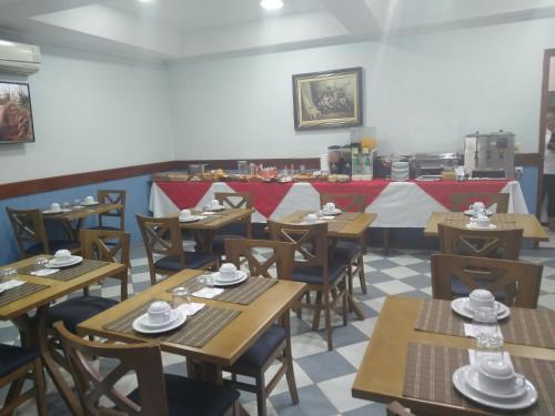 an empty restaurant with wooden tables and chairs at Filadelfia Hotel in São Paulo
