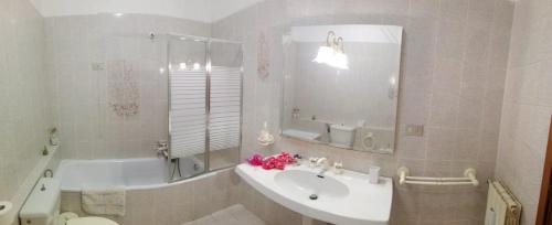 La salle de bains est pourvue d'un lavabo, d'une baignoire, de toilettes et d'un miroir. dans l'établissement A Casa Mia, à Cascina