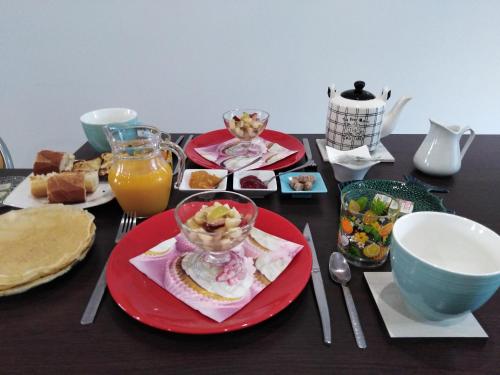 un tavolo ricoperto di piatti di cibo e un cesto di frutta di Les Chambres Hautes d'Anastasia a Rodez