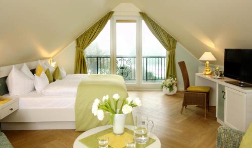 ein Schlafzimmer mit einem weißen Bett und einem großen Fenster in der Unterkunft Hotel Garni Inselparadies Zingst in Zingst