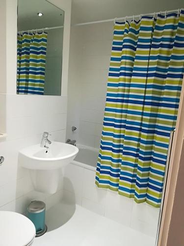 a bathroom with a sink and a shower curtain at Quality City Leicester in Leicester