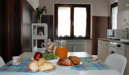 a table with bread and orange juice and croissants at Maison Teresa CIR 0161 in Aosta