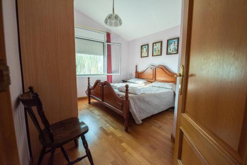 1 dormitorio con 1 cama, 1 silla y 1 ventana en Villa frente al Mar, en L'Ampolla