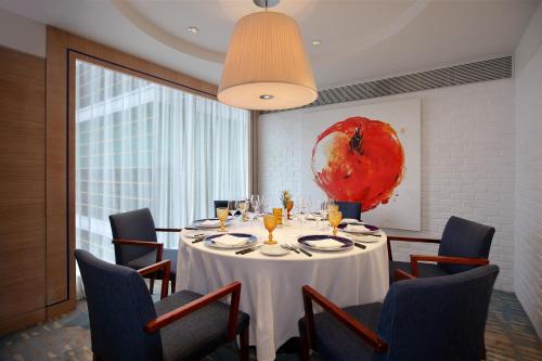 a dining room with a white table and chairs at Hotel Royal Macau in Macau