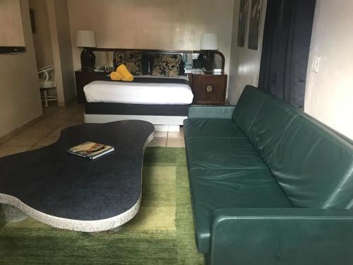 a living room with a couch and a bed at INN LEATHER GUEST HOUSE-GAY MALE ONLY in Fort Lauderdale