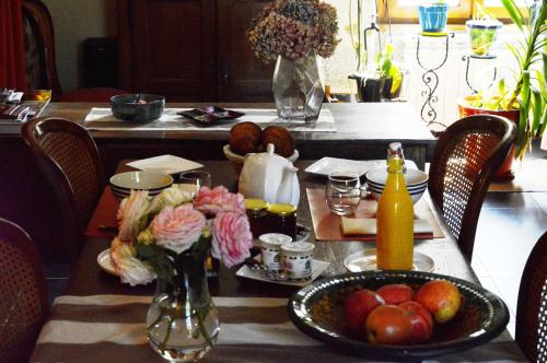 une table avec une assiette de fruits et légumes dessus dans l'établissement Les gîtes du bourg, à Vitrac