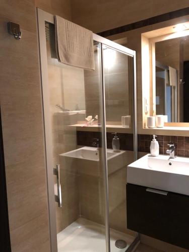 a bathroom with a glass shower and a sink at Apartament Morski in Świnoujście