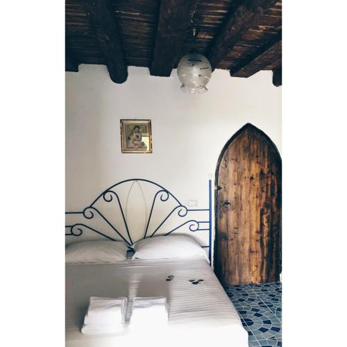 a bedroom with a bed and a wooden door at Domus Agricolae Corallina in Torre del Greco