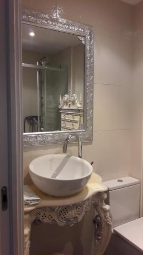 ein Badezimmer mit einem weißen Waschbecken und einem Spiegel in der Unterkunft Bakio Ocean View in Bakio
