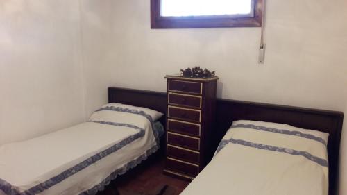 Zimmer mit 2 Betten, einer Kommode und einem Fenster in der Unterkunft Bakio Ocean View in Bakio