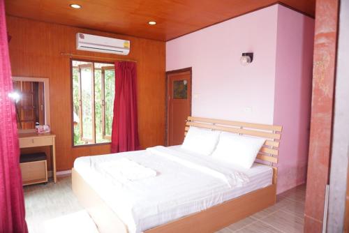 a bedroom with a white bed and a window at Mookanda bungalow in Ko Yao Noi