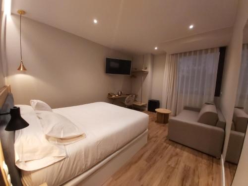 a bedroom with a white bed and a couch at Habital Suites in Jaca