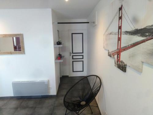 een hal met een stoel en schilderijen aan de muur bij Aux portes de l'Eure in Bonnières-sur-Seine