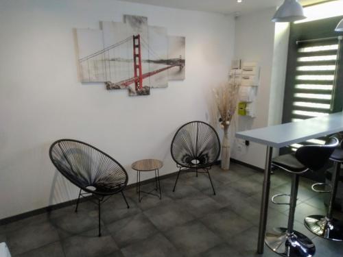 twee stoelen en een tafel in een kamer bij Aux portes de l'Eure in Bonnières-sur-Seine