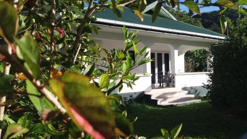 ein weißes Haus mit grünem Dach in der Unterkunft Destination Self-Catering in Grand'Anse Praslin
