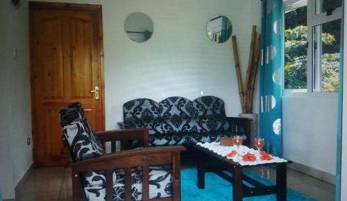 ein Wohnzimmer mit einem Sofa und einem Tisch in der Unterkunft Destination Self-Catering in Grand'Anse Praslin