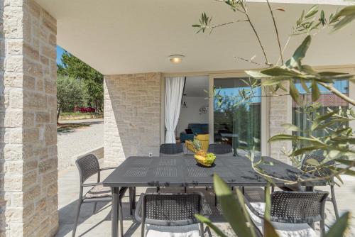 a patio with a black table and chairs at Guest House Ravnić in Poreč