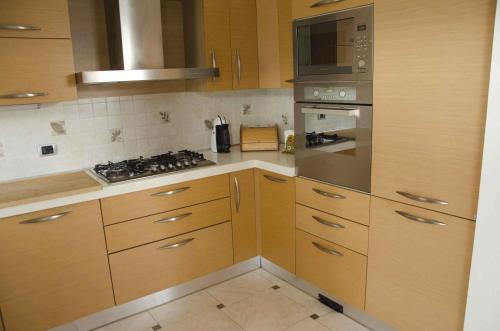 a kitchen with wooden cabinets and a stove top oven at Villetta Glicine in Brentonico