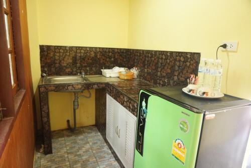 a small kitchen with a counter and a refrigerator at Mookanda bungalow in Ko Yao Noi