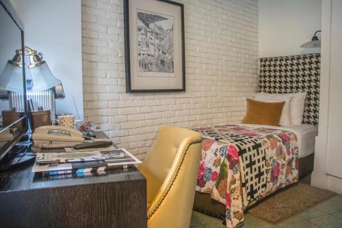 a bedroom with a bed and a desk with a desk at Center Chic Hotel - an Atlas Boutique Hotel in Tel Aviv