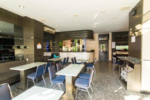 a restaurant with tables and chairs and a bar at Lovina Inn - Nagoya Batam in Nagoya
