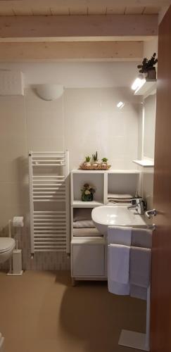 a white bathroom with a sink and a toilet at A casa di Mery in Negrar