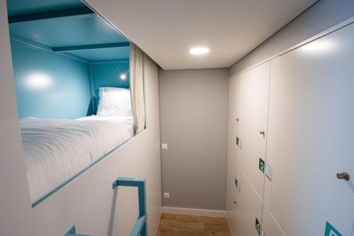 a small bedroom with a bed and a window at Ilha Hostel & Suites in Ponta Delgada