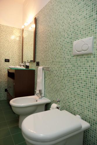 a bathroom with a white toilet and a sink at Mauro Home Bed and Relax in Linguaglossa