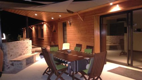 - une table à manger et des chaises sur la terrasse dans l'établissement la chambre du clos Barriant, à Séreilhac