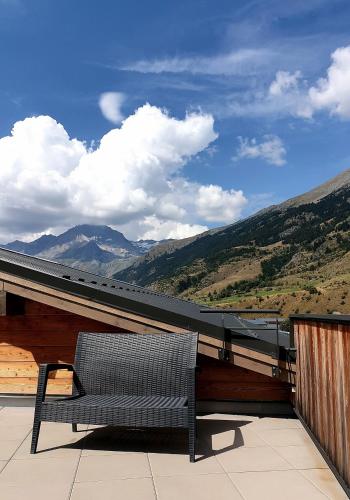 a bench sitting on a balcony with a view of mountains at CIS-Ethic Etapes de Val Cenis in Lanslebourg-Mont-Cenis