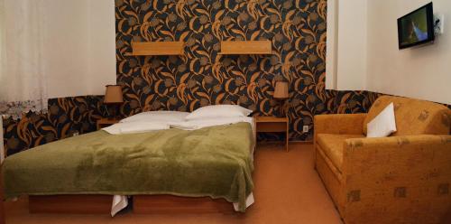 a bedroom with a bed and a chair at Penzion Horalka in Hlinsko