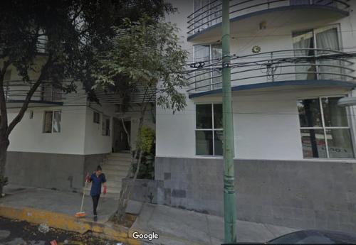 a person walking in front of a house at Becerra Apartments in Mexico City