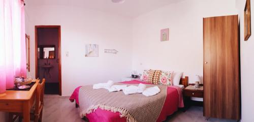 a bedroom with a bed with towels on it at Lefteris Rooms in Kámbos