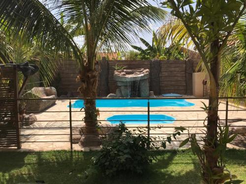 a swimming pool in a yard with two palm trees at Pousada Facincani in Olímpia