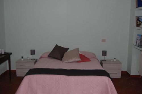 a bedroom with a large bed with two night stands at Affittacamere Loretta in San Giuliano Terme