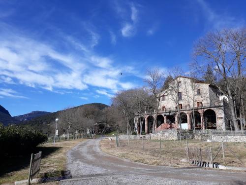un viejo edificio de piedra en un camino de tierra en Hotel rural La soleia d'Oix, en Oix