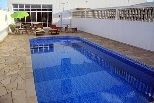 una gran piscina azul en la parte lateral de un edificio en Castelo Palace Hotel en Batatais