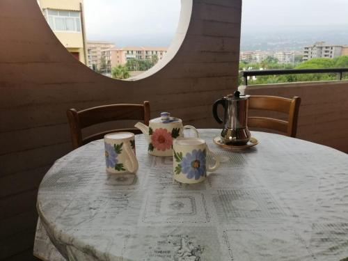 a white table with cups and teapots on it at Gess Etna Home in Giarre