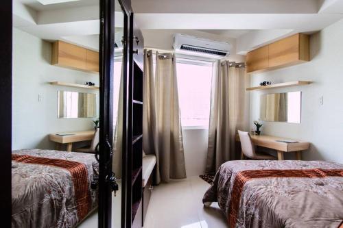 a hotel room with two beds and a window at Shell Residence Manila in Manila